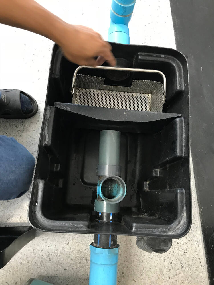 open grease trap with filter basket and pipes